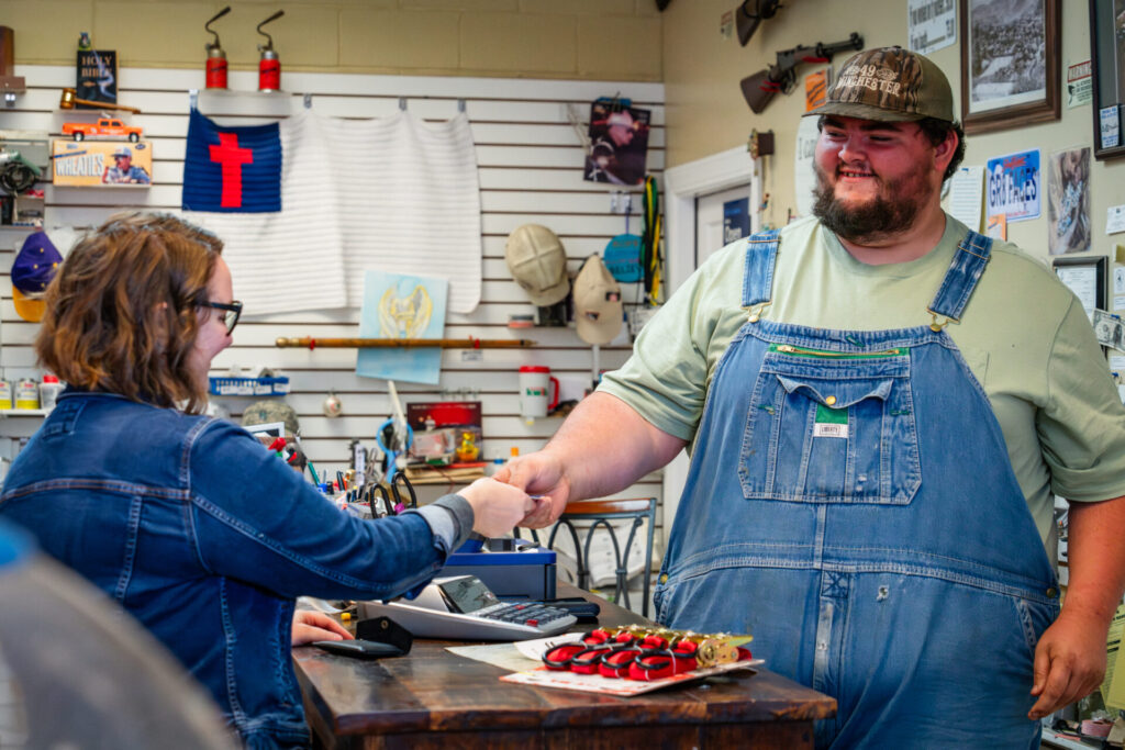 A Hometown Hardware employee helping a customer at the counter.